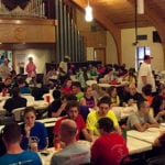 Mission trip and alternative break volunteers gather in the Camp Restore New Orleans dining hall for dinner.